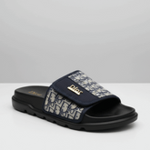 Navy slide sandal with patterned strap on a white background